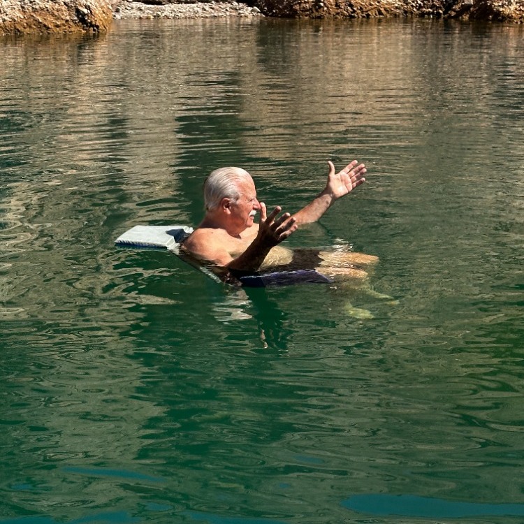 floating chair on river with man raising hands